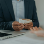 A businessman giving money to another person