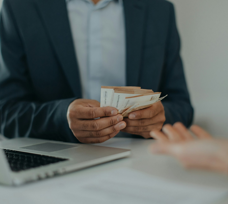 A businessman giving money to another person